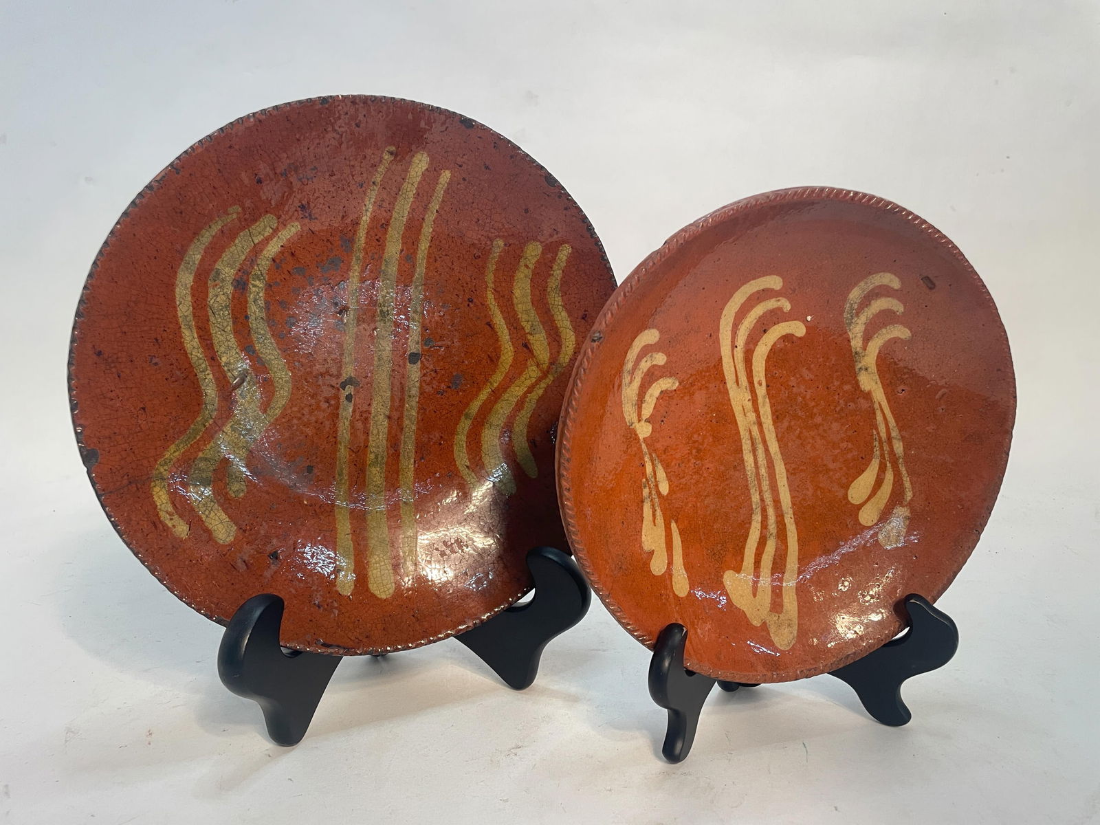 TWO SLIP DECORATED REDWARE PLATES. (1 of 5)