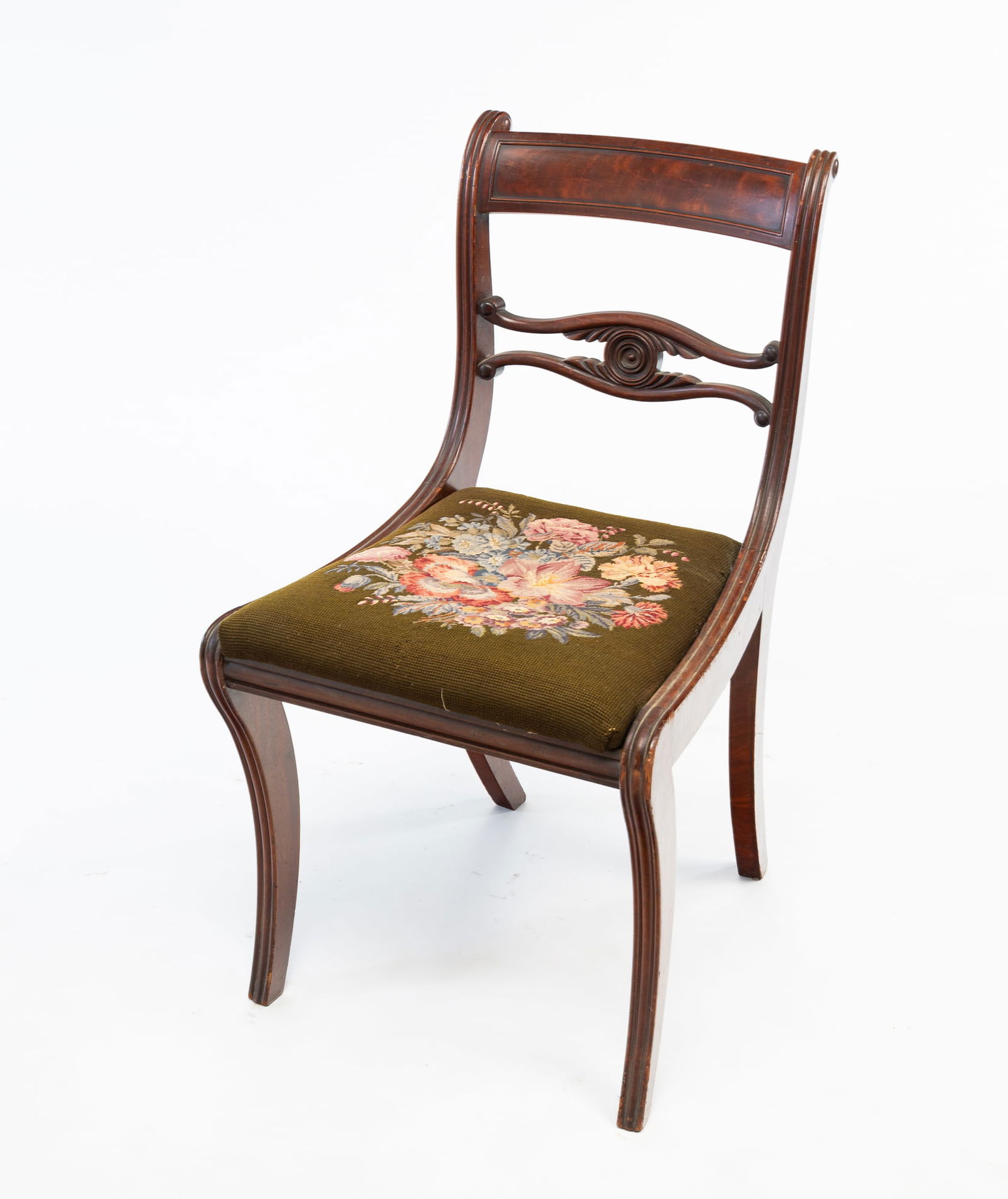 FEDERAL SABER LEG SIDE CHAIR.: American, Circa 1800, Mahogany. Reeded stiles, seat frame sides and front legs, paned crest, pierce carved splat and floral needlepoint slip seat. 17.5"h, seat ht. 38"h. From the collection of Mark an