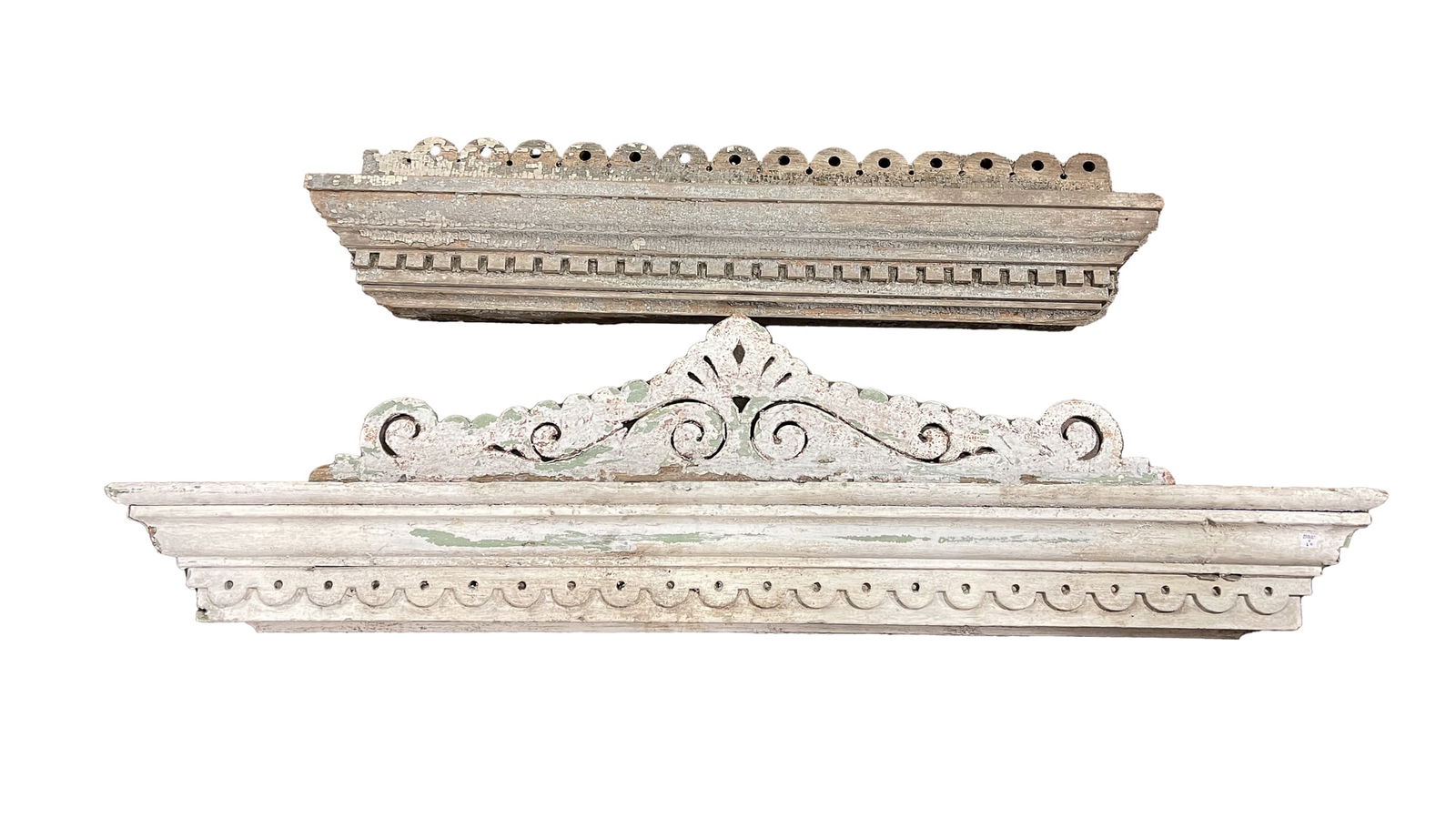 TWO VICTORIAN EXTERIOR WINDOW LINTELS.: American, second half 19th Century. Poplar. One has jigsaw cut crest, heavy cornice moldings and lower scalloped course. Weathered white paint. 15.5"h. 61"w. And the second with scalloped crest, heavy