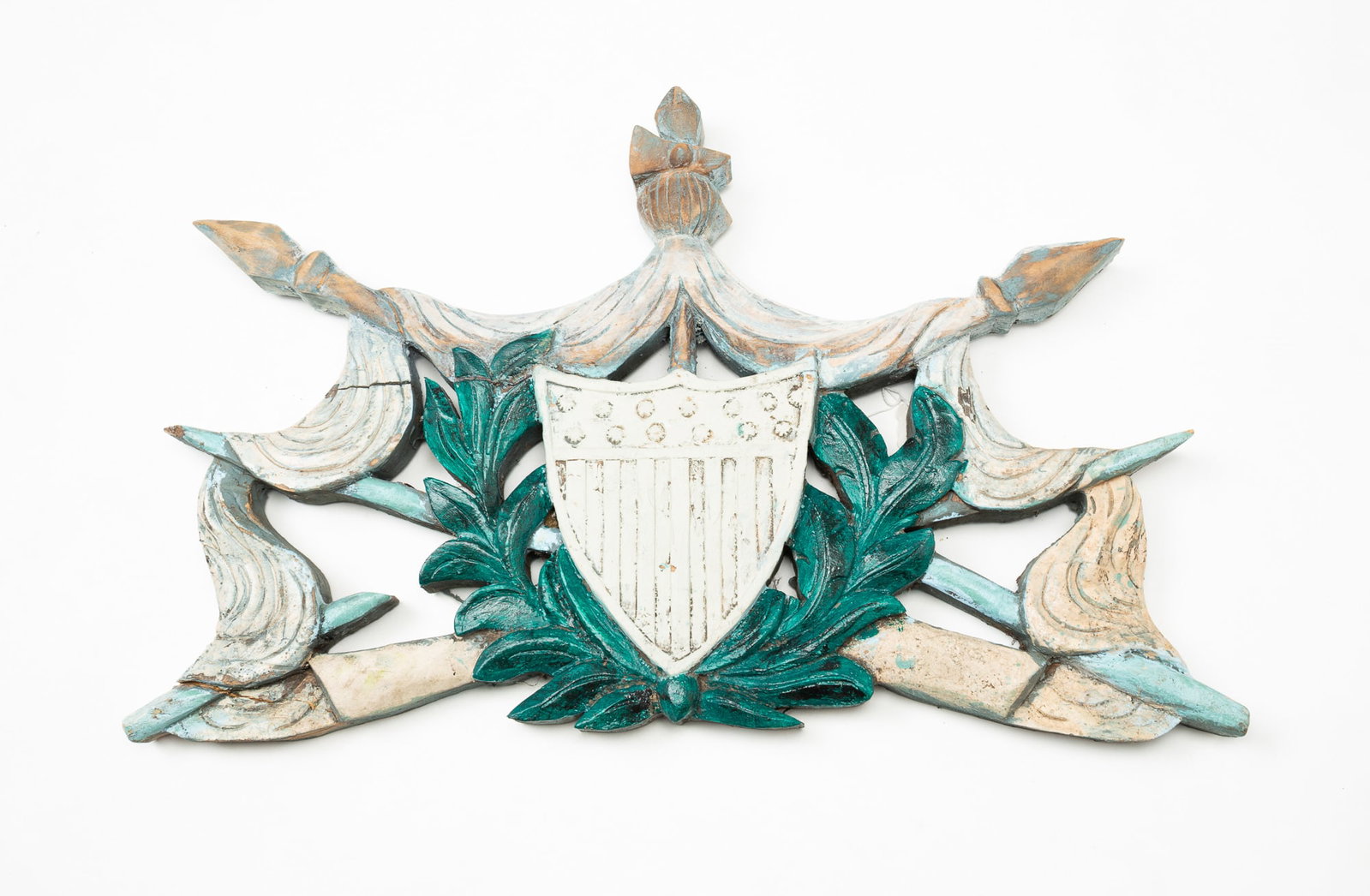 AMERICAN SHIELD CARVED WOODEN PLAQUE.: American, mid-19th Century. Softwood. Shield with thirteen stars surrounded by olive branch wreath and draped spears. 14.5"h. 24.5"w.