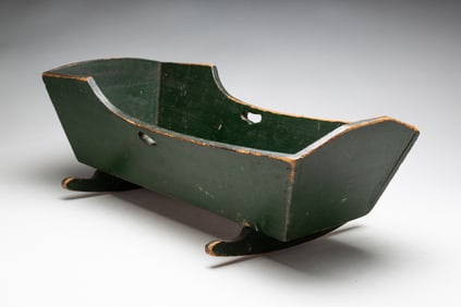 AMERICAN GREEN-PAINTED PINE CRADLE WITH HEART-SHAPED CUTOUTS.
