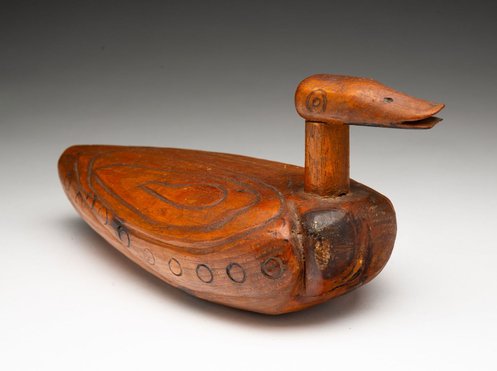 AMERICAN FOLK ART CARVED DUCK DECOY.: American, 20th Century. Carved duck with incised decoration, long neck, and head with open bill. 4.5"h. 9.25"d.