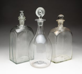 THREE BLOWN GLASS BOTTLES WITH STOPPERS, INCL. GILT-DECORATED EXAMPLE.