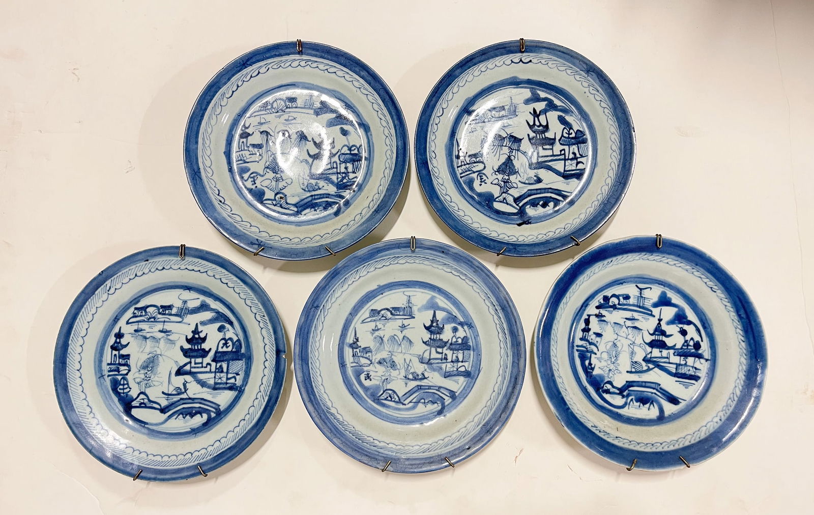 GROUP OF BLUE AND WHITE CANTON PORCELAIN PLATES.: Chinese, 19th Century. In typical decoration, 8.5" plates with plate holders attached.