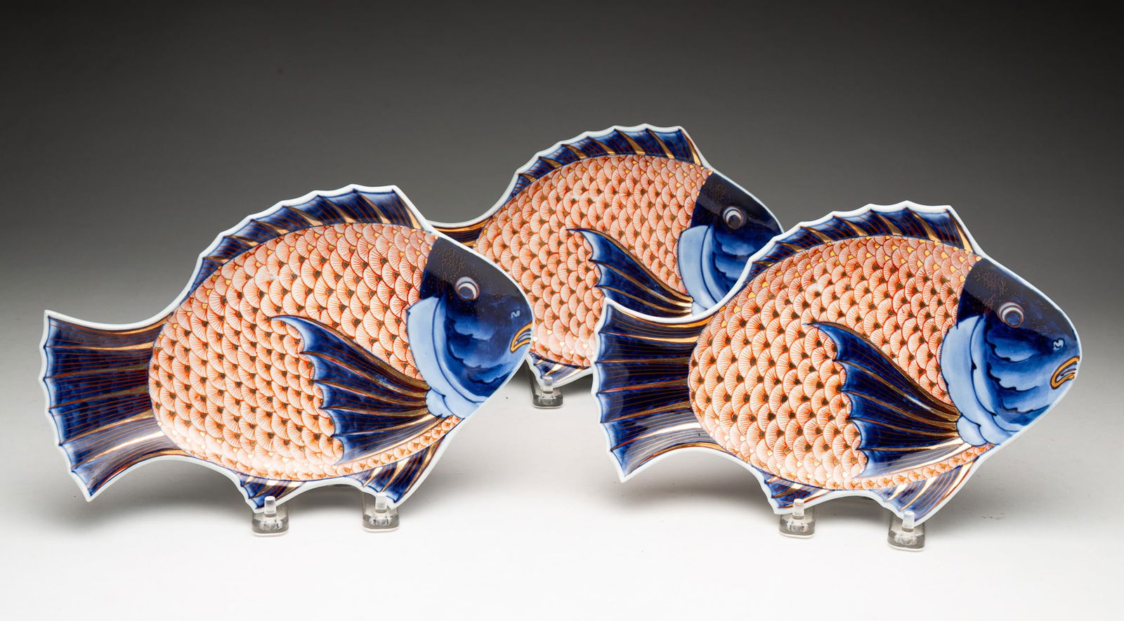 THREE JAPANESE ARITA PORCELAIN FISH FORM PLATES.: Japan, 19th Century. Polychrome and gilt decorated, each having an Arita mark on underside. 6.75"h. 10"w.