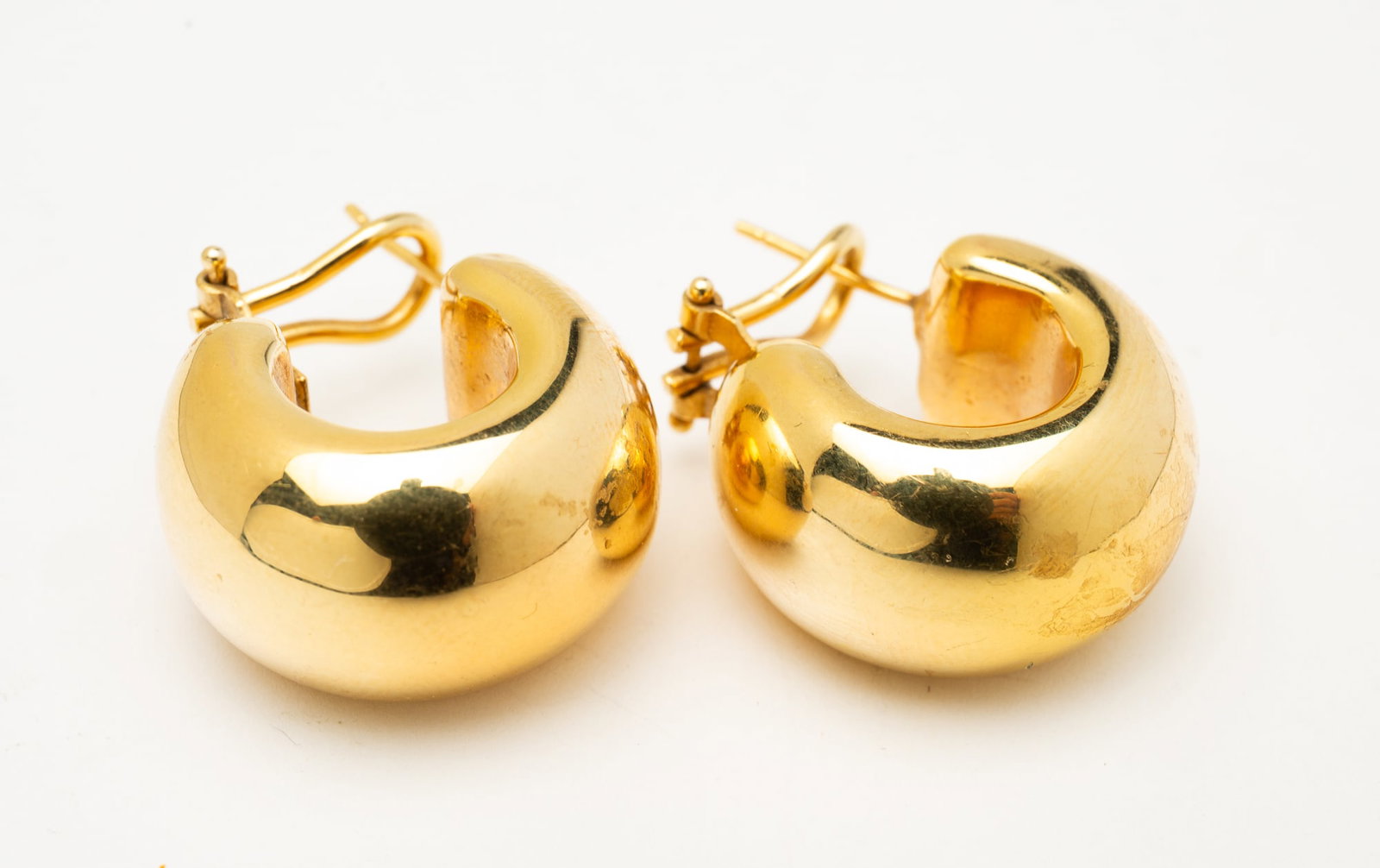 A PAIR OF 18K YELLOW GOLD HOOP EARRINGS.: Contemporary. 18k yellow gold. Puffy hollow hoops with omega backs. Approximately 8.7 g.