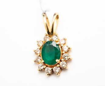 14 KARAT EMERALD AND DIAMOND HALO PENDANT.