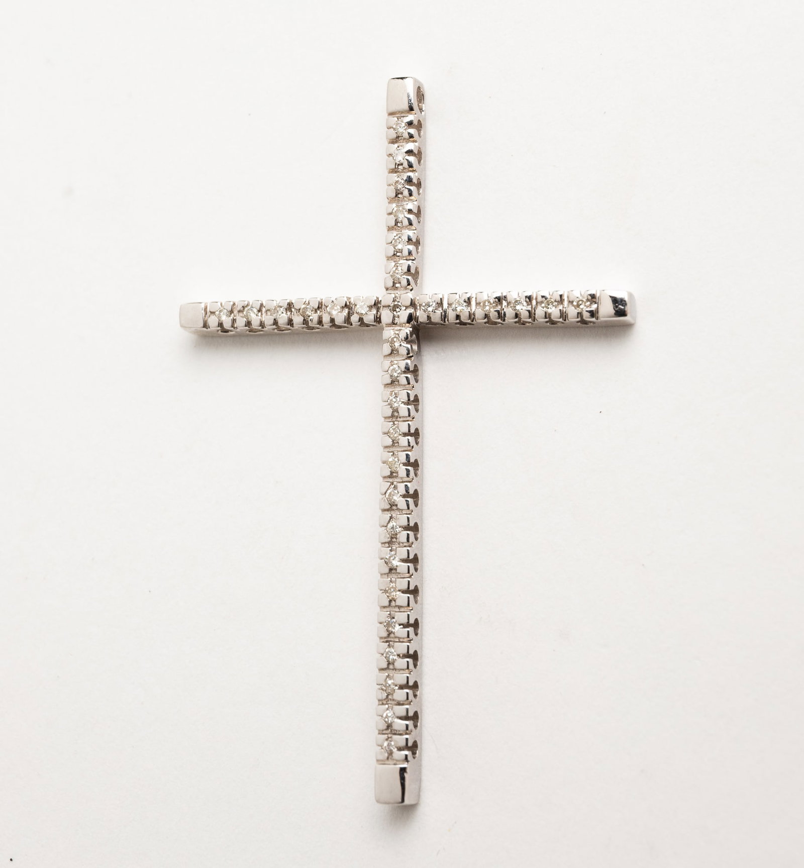 14K WHITE GOLD AND DIAMOND CROSS PENDANT.: Contemporary. Cross measures approx. 1.87"l x 1.25"w, set throughout with twenty small round diamonds. Pendant weighs 3.9gr.