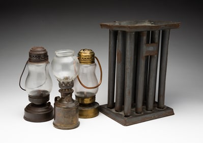 THREE BRASS AND TIN LAMPS PLUS TWELVE-TUBE CANDLE MOLD.