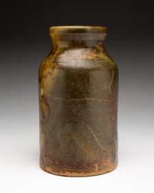 AMERICAN BUFF CLAY BOTTLE IN MOTTLED GLAZE.