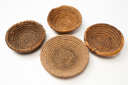 FOUR RYE STRAW BASKETS.