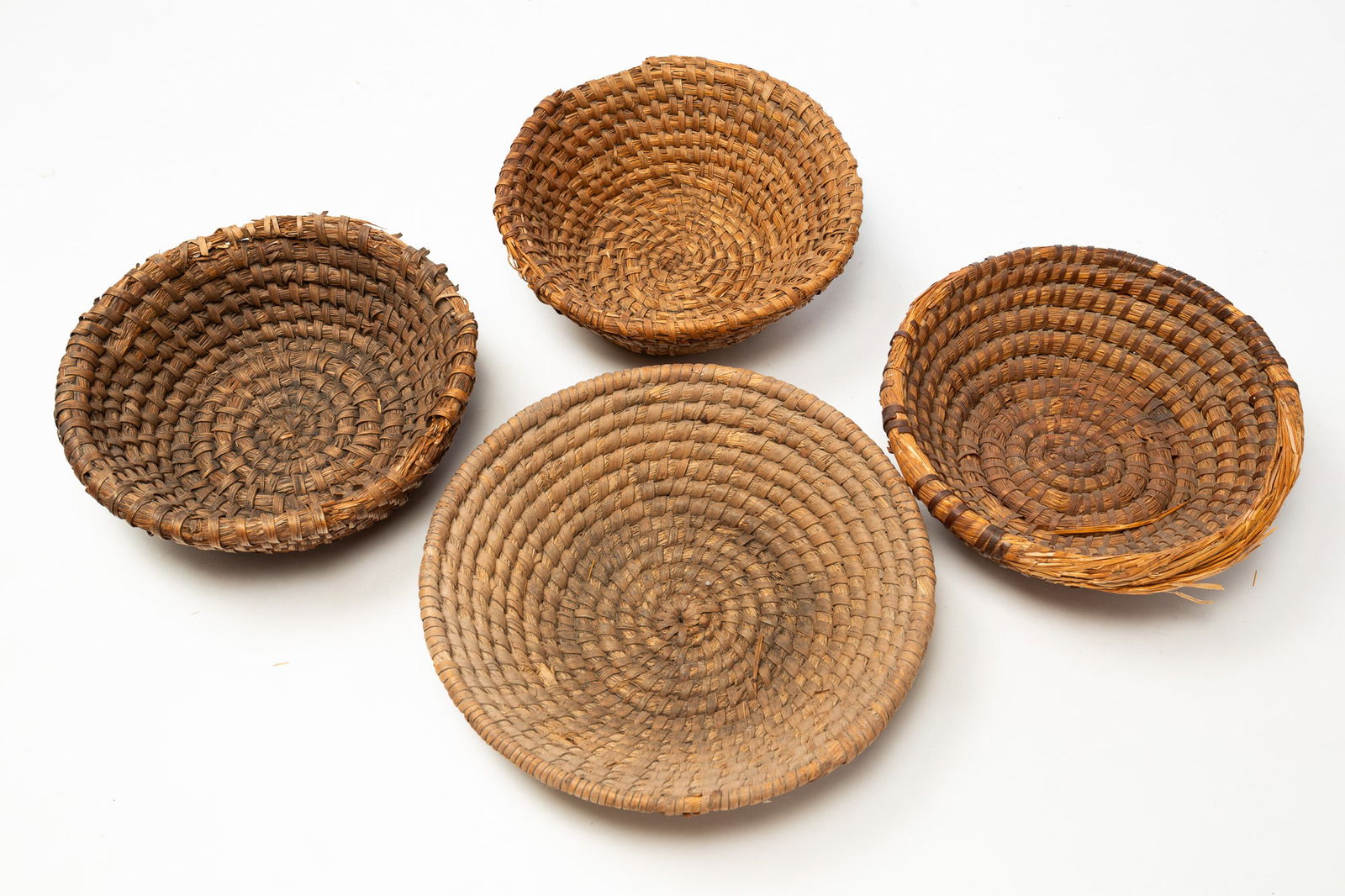 FOUR RYE STRAW BASKETS. (1 of 2)