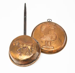 TWO COPPER FOOD MOLDS EMBOSSED WITH ANIMALS.