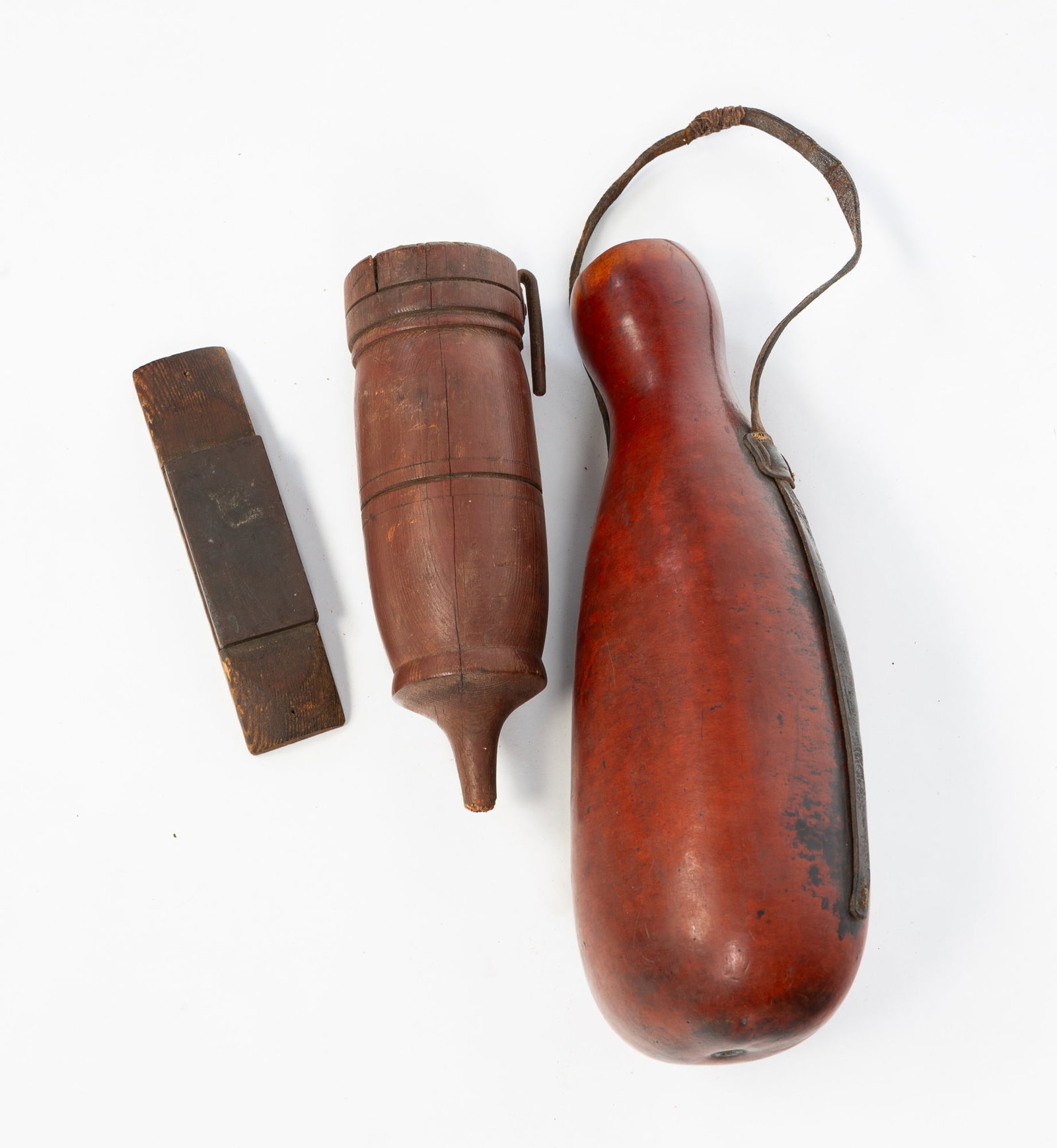 PAINTED TREEN WALL POCKET AND A GOURD CANTEEN.: American. Nicely turned wall pocket with reddish-brown paint, forged iron hanger with a honing stone, 10"h. And a gourd canteen with leather strap, 15"h.