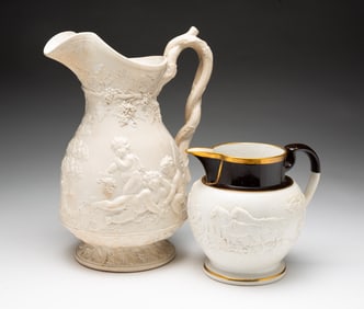 TWO ENGLISH PORCELAIN RELIEF MOLDED PITCHERS, ONE BY JOHN RIDGWAY.