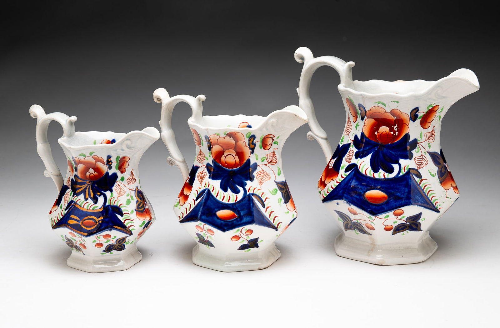 THREE ENGLISH GAUDY EARTHENWARE JUGS.: England, 19th Century. Molded earthenware with gaudy Imari-type decoration. Largest, 7.75”.