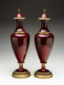 PAIR OF PAUL MILET (FRENCH, 1870-1950) FOR SEVRES ORMOLU-MOUNTED PORCELAIN URNS.