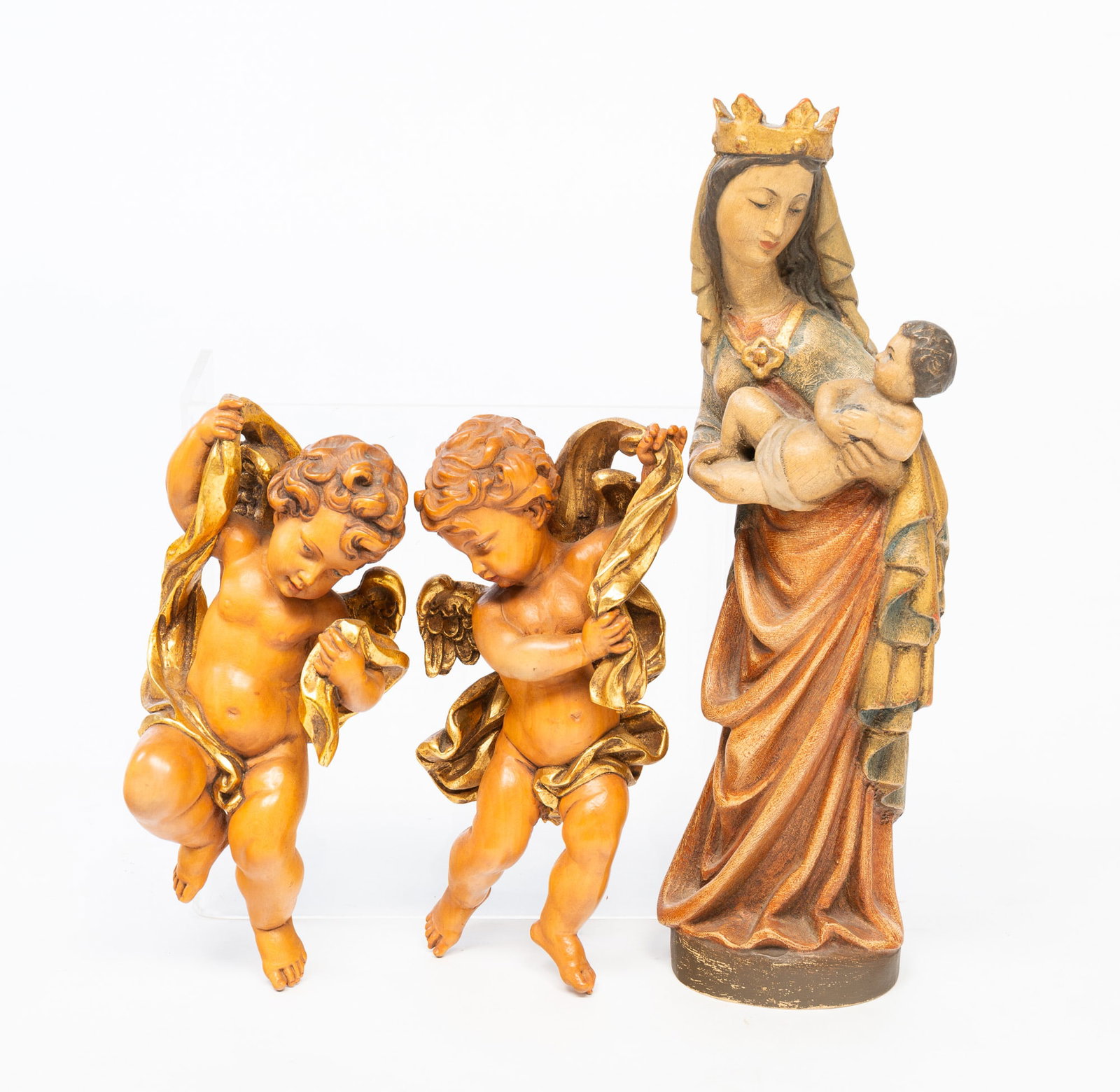 CARVED MADONNA AND CHILD AND TWO CHERUBS.: European, 20th Century. Salzburg, Austria, Madonna and Child in muted colors, 16.25"h. And a mirrored pair of Cherubs with gilded sashes and wings, 10"h.