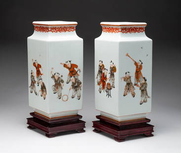 PAIR OF CHINESE FAMILLE ROSE DIAMOND FORM PORCELAIN VASES.: China, late 19th Century. The neck decorated with a scrolling foliage motif, the sides decorated with scenes of children playing, raised on diamond form stepped wooden bases, unmarked. Each (with base
