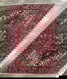 PERSIAN HERIZ ROOM SIZE RUG.: Iran, 20th Century. Wool. Hand knotted. Red field with all over geometric pattern, large patterned border with fringe to either end. 10' 11"l. 8' 4"w.