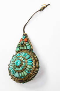 TIBETAN BRASS AND TURQUOISE CEREMONIAL NEW YEAR'S BROOCH, CHEPPU, OR MOONEATER.: Tibet (Lhasa), ca. 1900. Brass brooch in the shape of a circle with tall triangle on top, the front inset with several turquoise stones and two corals, the sides inset with several blue and green ston