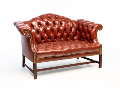CHIPPENDALE STYLE BUTTONED-DOWN LEATHER CAMELBACK LOVESEAT WITH BRASS TACKS.