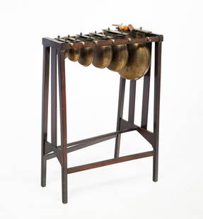 MANNER OF STICKLEY, ARTS AND CRAFTS SOUTHERN GUM AND BRASS XYLOPHONE DINNER CHIMES.: Manner of Stickley, Early 20th Century. Southern gum and brass bells. Arts and Crafts stand with six brass bells with notes to the tops. 30"h. 21.5"w.