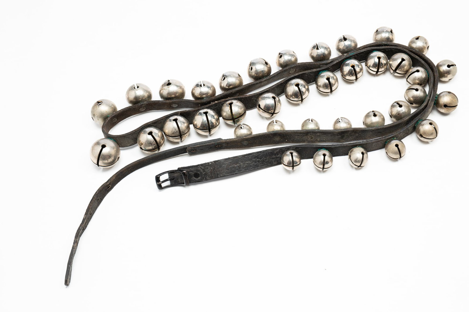 LEATHER STRAP WITH SILVER SLEIGH BELLS.: American, 19th Century. Long strap with 37 silver bells in graduated sizes. 92"l.