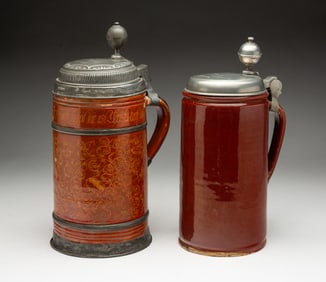 TWO GERMAN GLAZED EARTHENWARE STEINS.