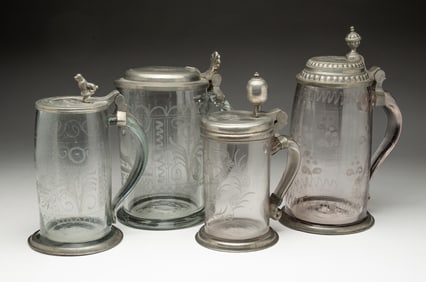 FOUR GERMAN BLOWN AND ETCHED GLASS BEER STEINS.