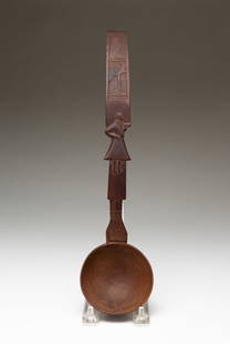 FOLK ART CARVED SPOON WITH PREACHER.: Late 19th-early 20th Century. Hardwood. Carved hand cradling the bowl, handle with preacher holding bible, a standing bird to the top and a loop at handle end. 13.25"l.