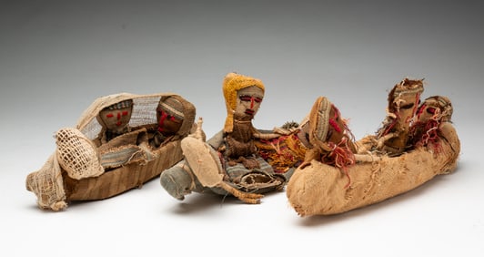 THREE GROUPS OF PERUVIAN CHANCAY CLOTH BURIAL DOLLS IN CANOES.