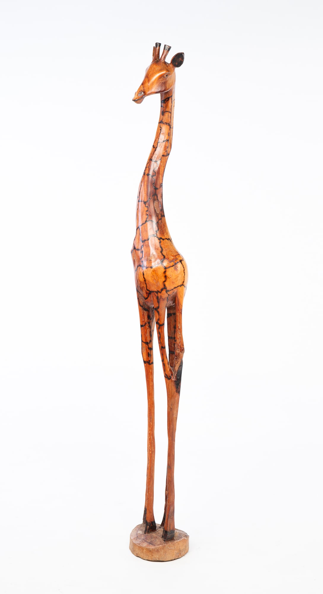 CARVED GIRAFFE.: 20th Century, Possibly ironwood. Well carved with pyrographic detail. 58.5"h. From the Collection of Tom and Lenore Karras (Geneva, Illinois).