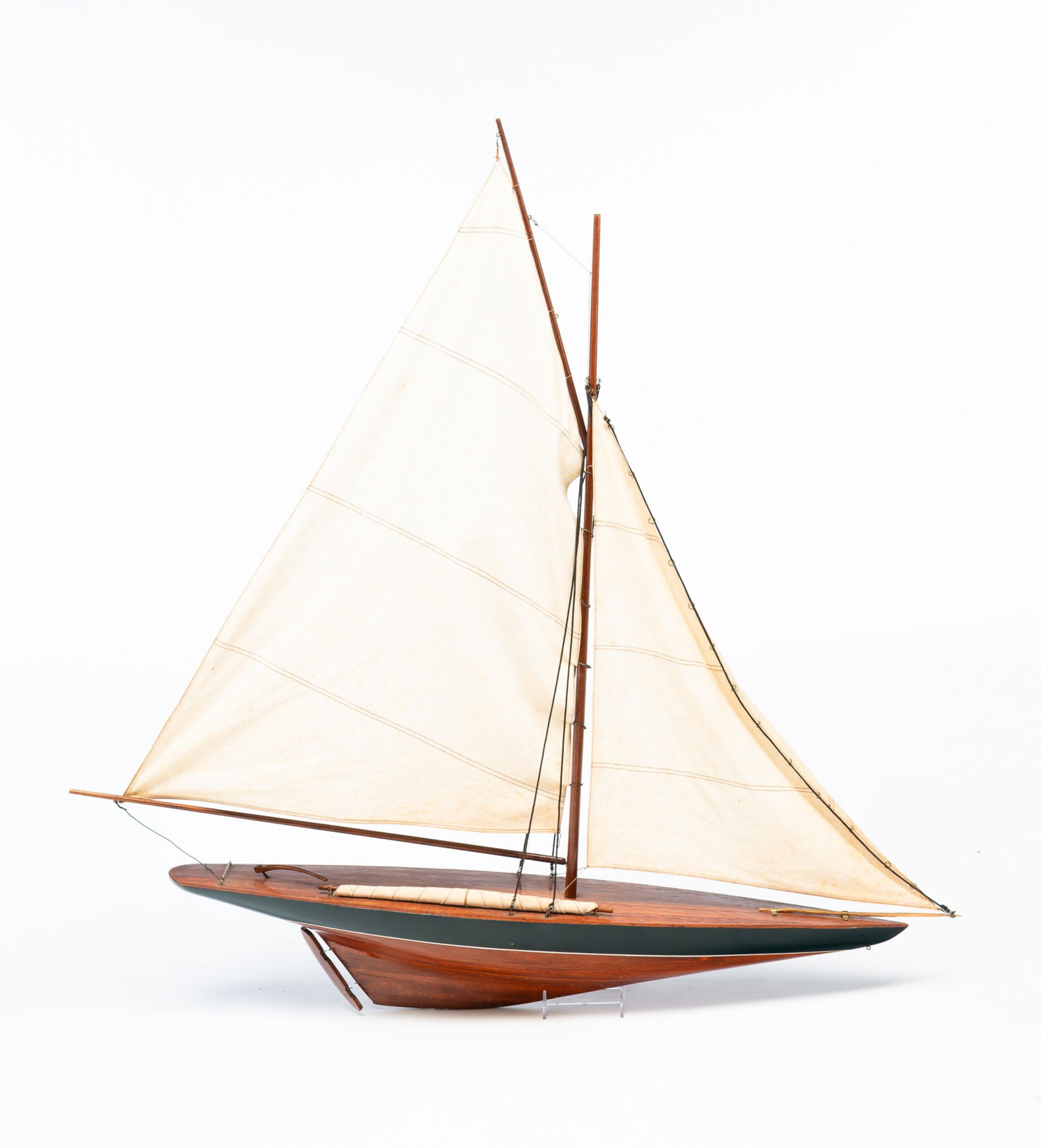 AMERICAN POND SAILER MODEL.: American, 20th century. Scale model of a wooden boat having two stitched linen sails. 41"h. 43"w. From the collection of Mark and Sandy Keily.