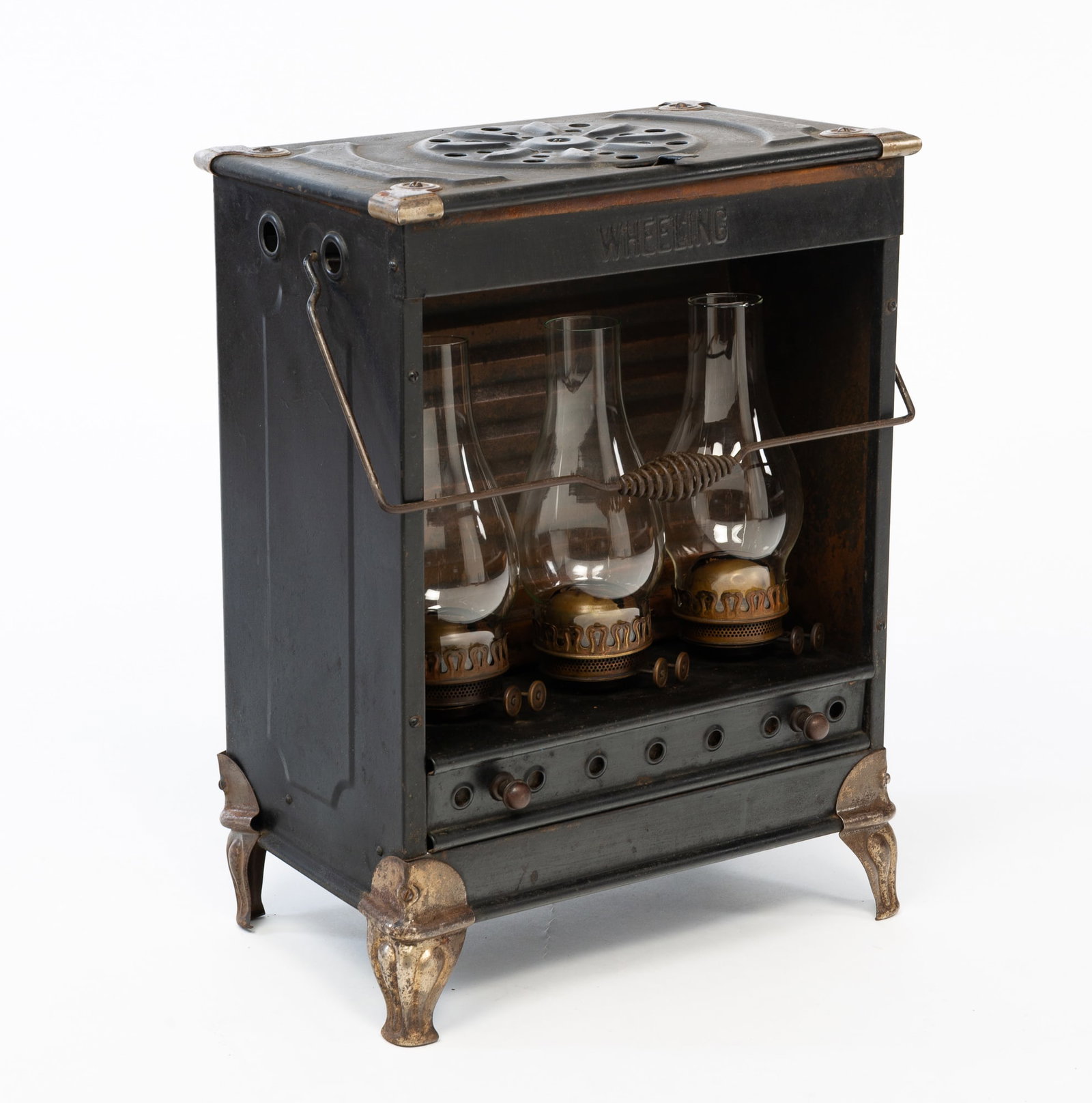 "WAGELING" KEROSENE LAMP/STOVE.: American (West Virginia), Late 19th Century. Tin housing with nickel-plated corners and feet, wire bale handle and three burners with clear chimneys. 21"h. 15.75"w. 10''d.