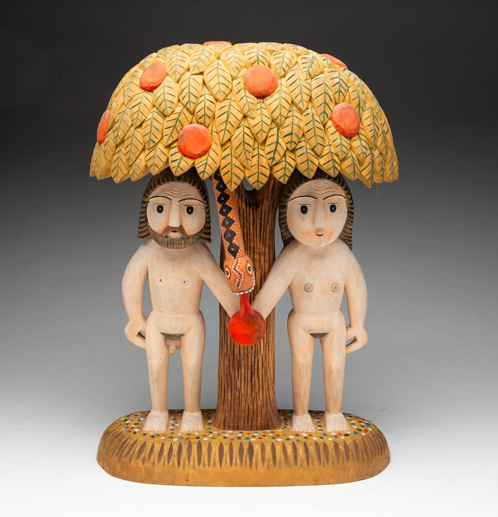 TADEUSZ KACALAK ADAM AND EVE WOOD CARVING.: Polish, Contemporary. Pine. Well carved and brightly painted with Adam and Eve beneath the tree of knowledge, the Serpent dangling from the canopy tempting them with the forbidden fruit. Carved signat