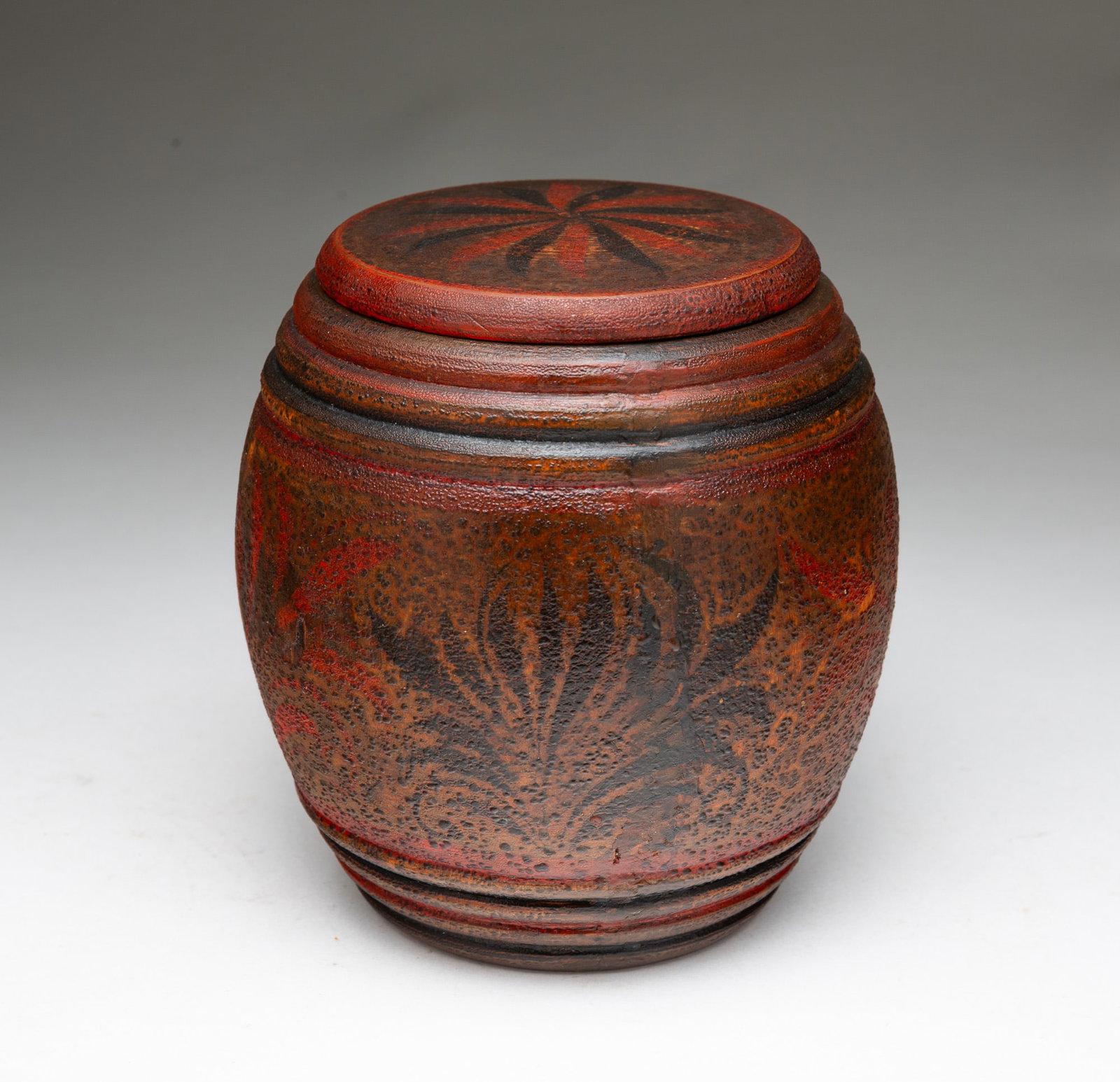 EUROPEAN KEG-SHAPED TEA CADDY WITH PAINTED DECORATION.: European, 19th Century. Red paint with black and red pinwheel and foliate decoration. Silver foil lining. 5.5"h.