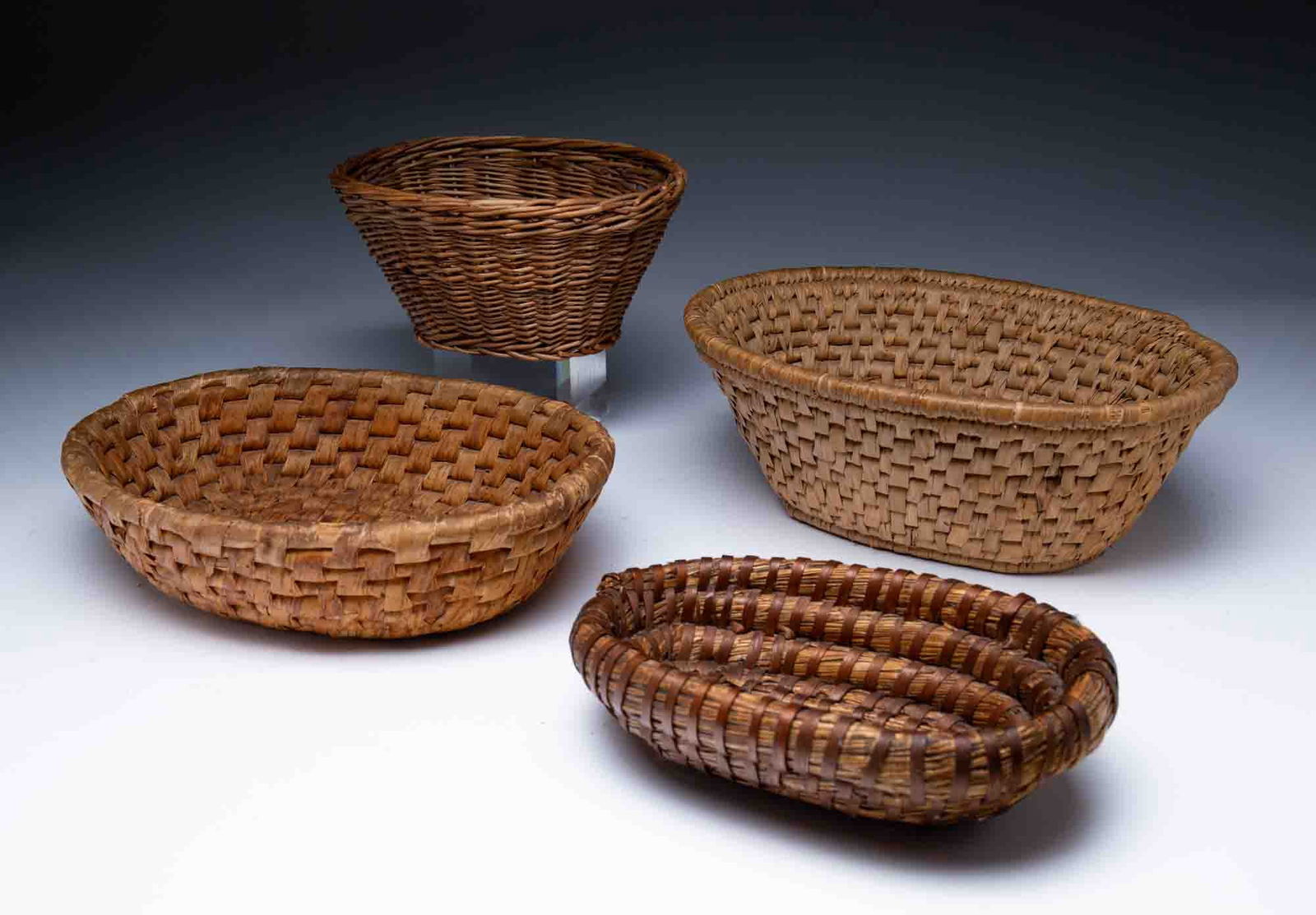 THREE AMERICAN COIL WOVEN GRASS BASKETS AND A RATTAN BASKET. (1 of 6)