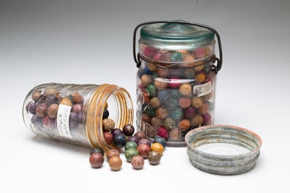 TWO JARS OF CLAY MARBLES.