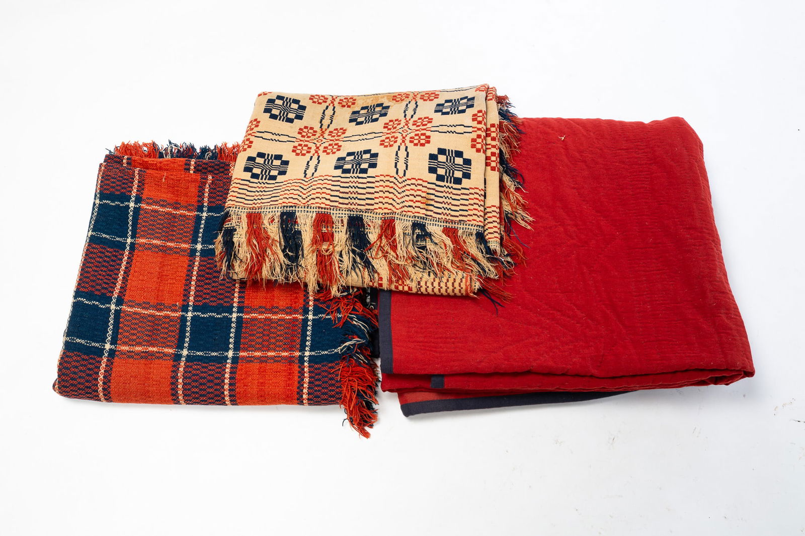 THREE AMERICAN COVERLETS.: American, 19th Century. A jacquard coverlet in red, blue and white plaid with fringe and initials "C.M." to the corner, 86"l. 76"w. A Summer-Winter jacquard coverlet with geometric patterns in red, wh