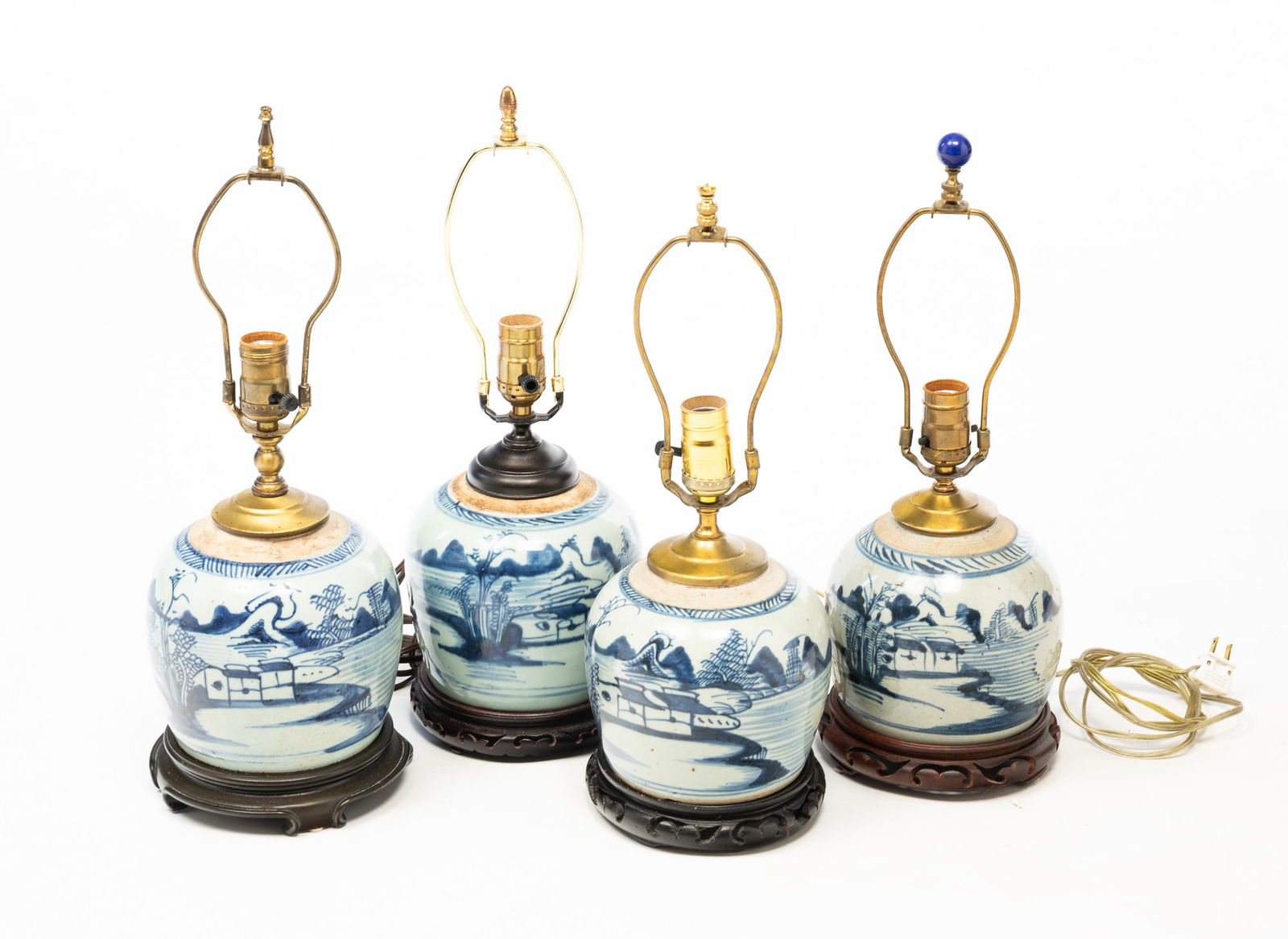 FOUR CHINESE BLUE AND WHITE CANTON PORCELAIN GINGER JAR LAMPS.: China, 19th Century. All decorated with pagodas, mountains, trees, water, boats, and fisherman, all having wooden bases and harps with finials. Tallest jar, 6.5"h. Overall, 18.5"h. Provenance: From Th