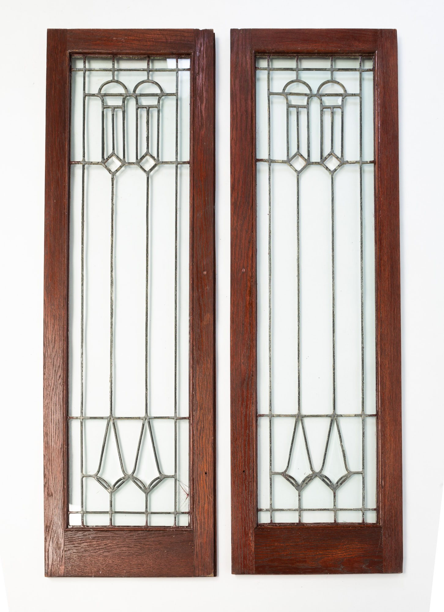 A PAIR OF AMERICAN LEADED GLASS DOORS.: American, ca. 1900. Geometric pattern with some beveled pieces. In oak frames. 47.25”h. 14.5''w.Provenance: From the Lifetime Collection of the Late Ray Yoder (Bay Village, Ohio).