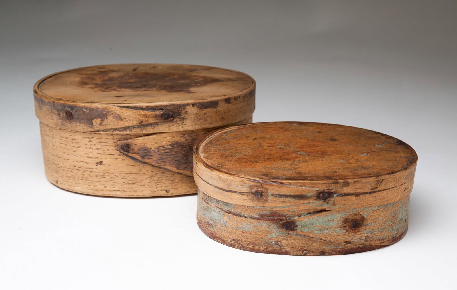 TWO AMERICAN OVAL BENTWOOD PANTRY BOXES.: American, 19th Century. Two oval graduated pantry boxes, finger joints, iron tacks and traces of old paint. 2.75"h. 6.5"w. and 2"h. 5.75"w.