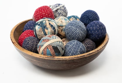 AMERICAN PAINTED TURNED BOWL FILLED WITH CARPET BALLS.
