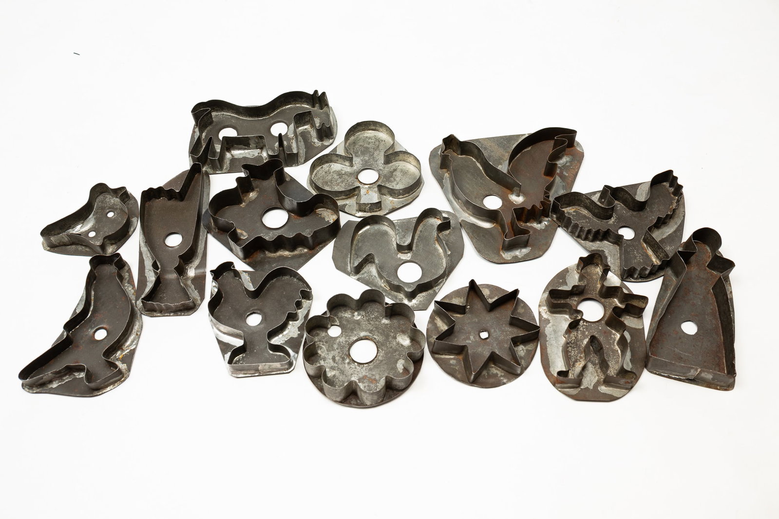 GROUP OF AMERICAN TIN FIGURAL COOKIE CUTTERS.: American, Late 19th-early 20th Century. Fourteen cutters in various forms. Including horse, people, roosters, and shapes. From 5.5"h. 2.5"h.