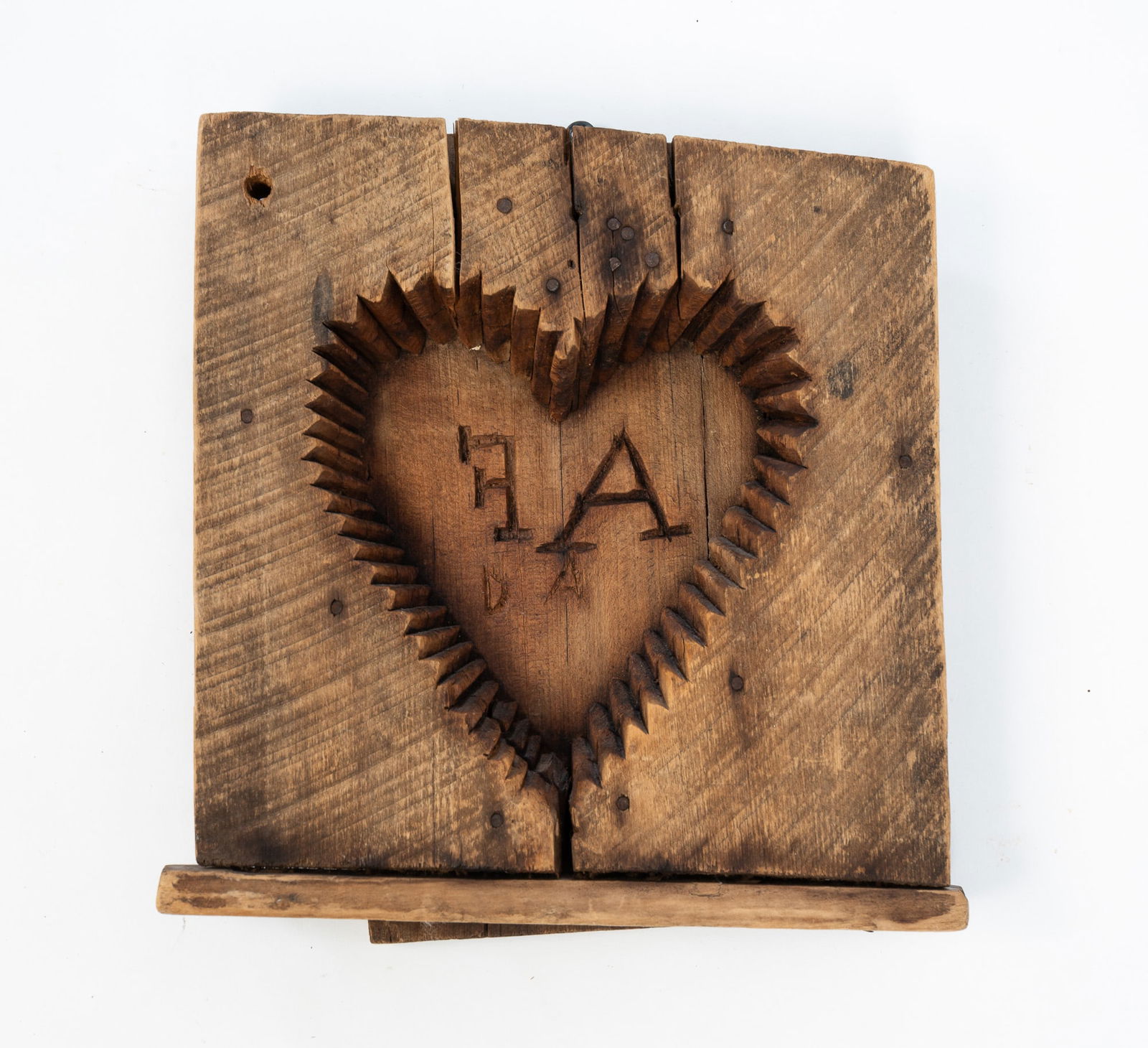 AMERICAN HEART-FORM MAPLE SUGAR MOLD WITH INITIALS.: American, ca. 1900. Carved wood mold in the shape of a heart, with crenulated edges, the center with the initials "A F" and "D A". 12"h. 11"w.
