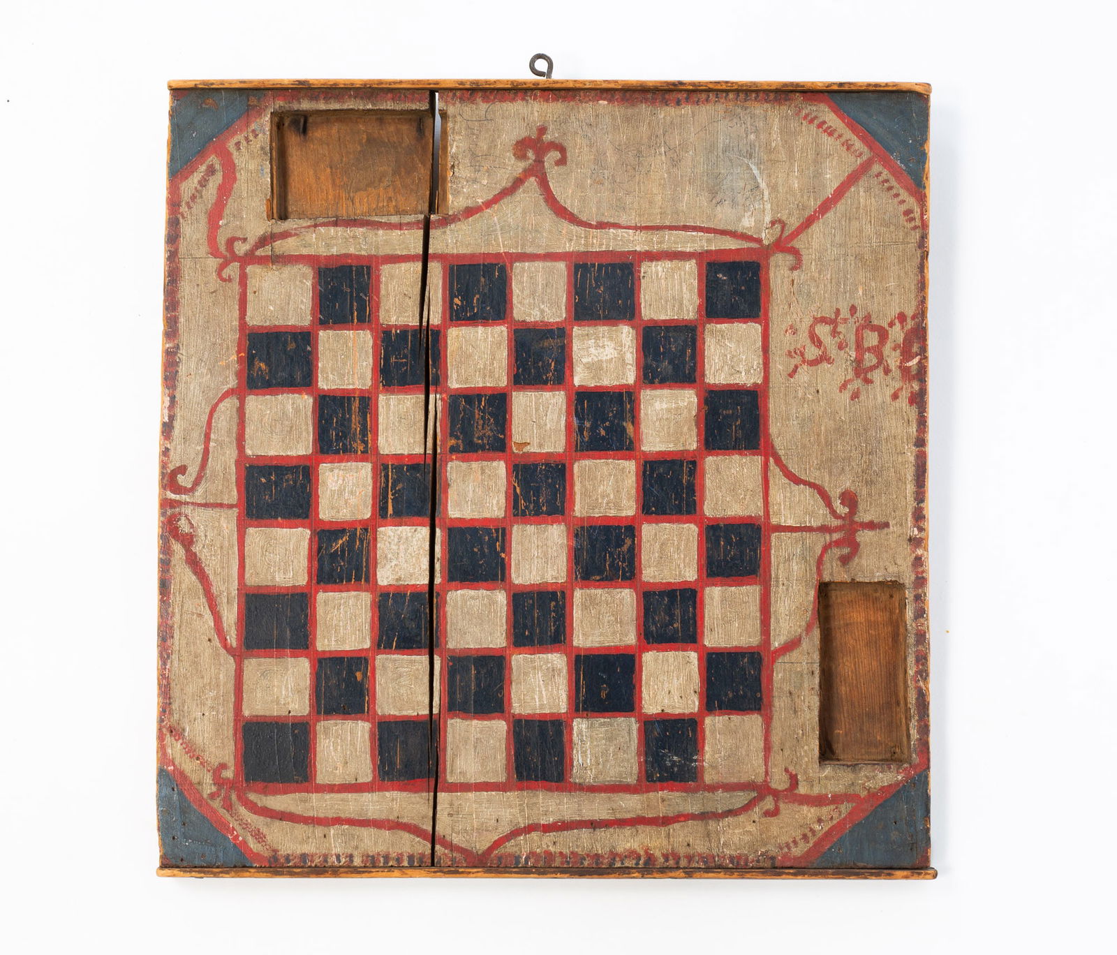 AMERICAN FOLK ART PAINT-DECORATED GAMEBOARD.: American, Late 19th Century. Checkerboard with cut-out wells to either side, applied edge molding at top and bottom, decorated in gray, red, black and blue paint, and initialed "S.B.B." to side and to