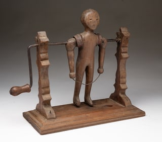 AMERICAN FOLK ART CARVED WALNUT CRANK-ACTION JUMP ROPING FIGURE.
