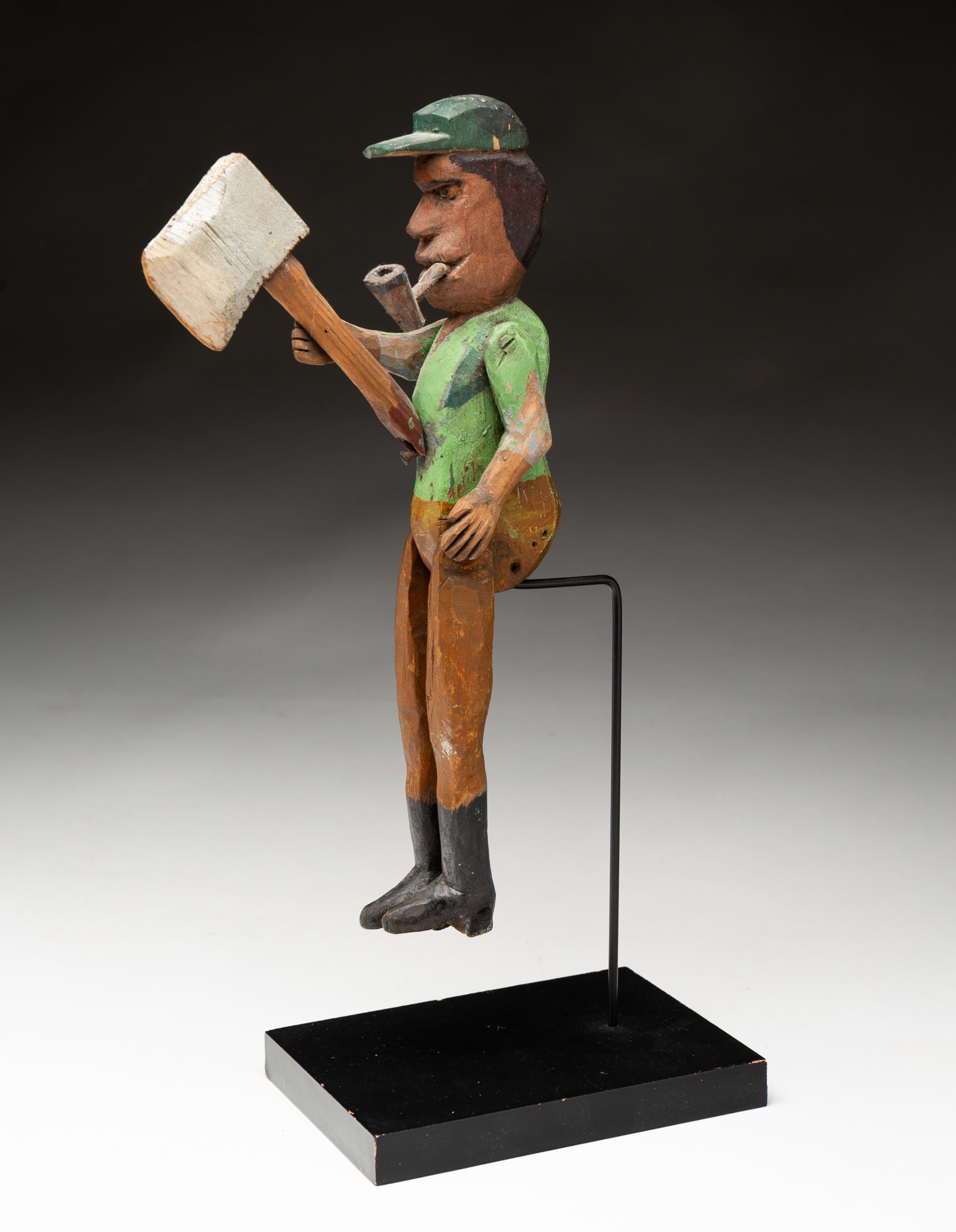 AMERICAN FOLK ART CARVED AND PAINTED "THE WOODCHOPPER" FIGURE.: American, 20th Century. Articulated man figure holing an axe and smoking a pipe. May have been from a whirligig. 11"h.
