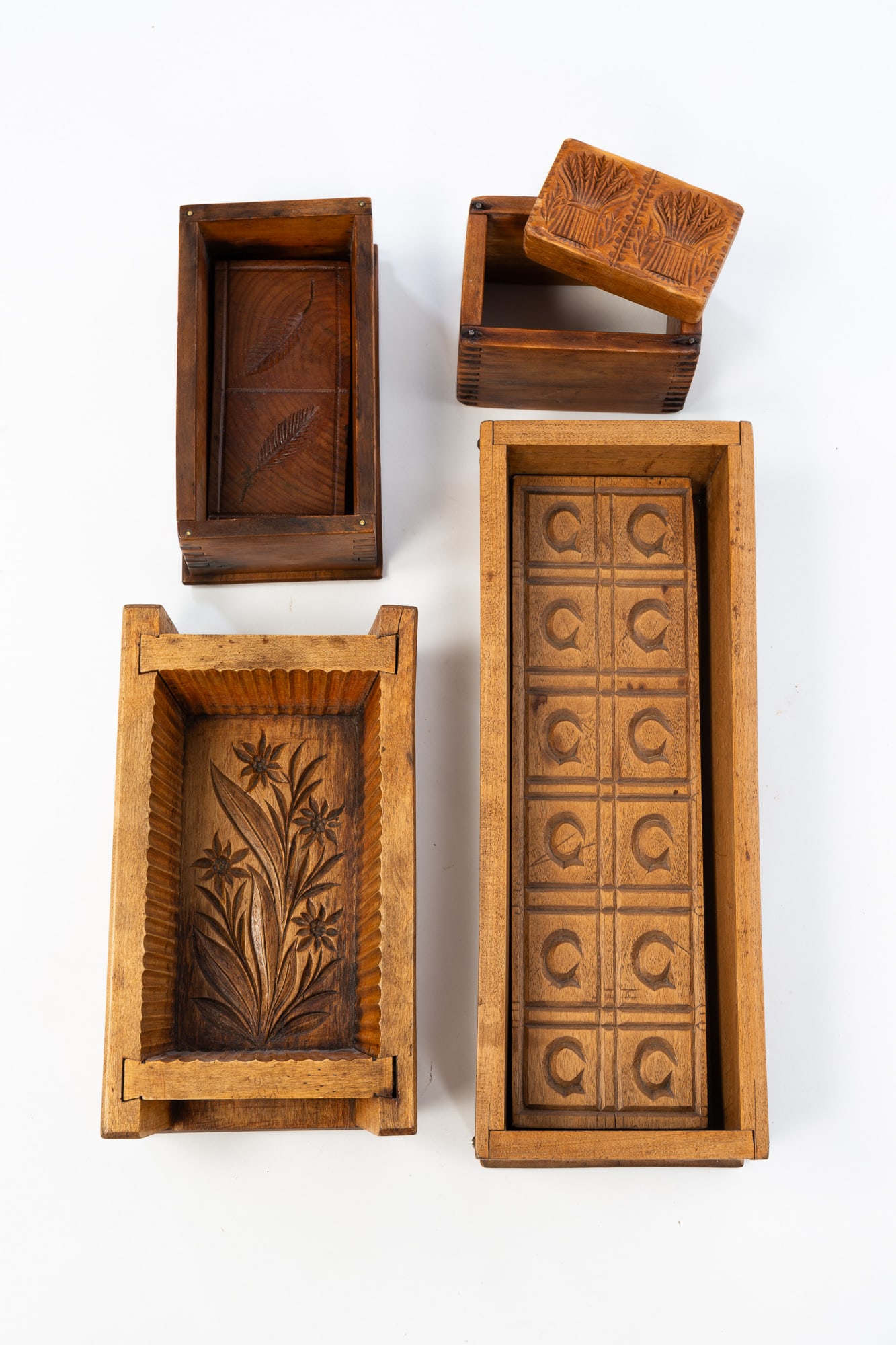 FOUR AMERICAN CASED BUTTER MOLDS.: American, Late 19th and Early 20th Century. Rectangular box molds featuring the letter C, leaves, flowers, and sheaves of wheat. Largest, 3"h. 14.5"w. 5.5"w.